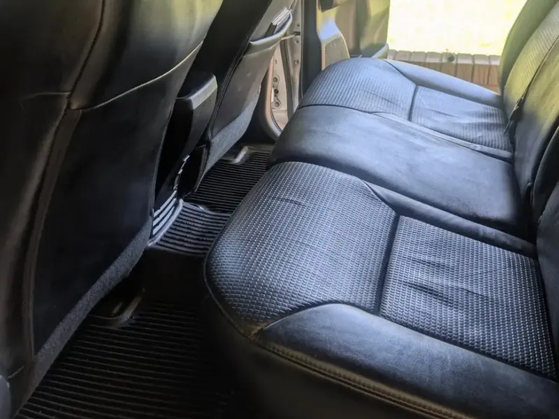 Black leather rear seat and floor mats cleaned inside a vehicle