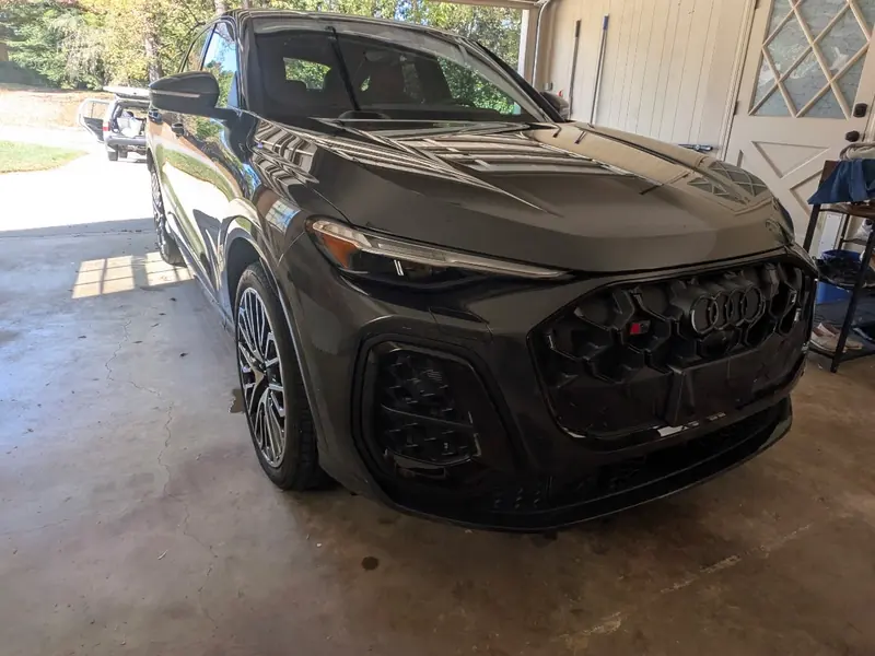 Dark gray SUV being detailed in a garage