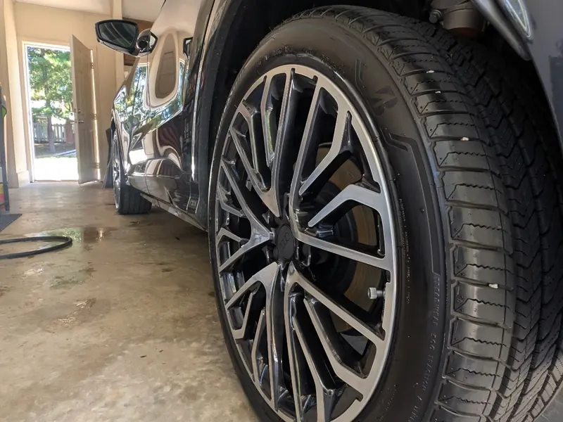 Close-up of a clean alloy wheel and tire on a dark gray SUV