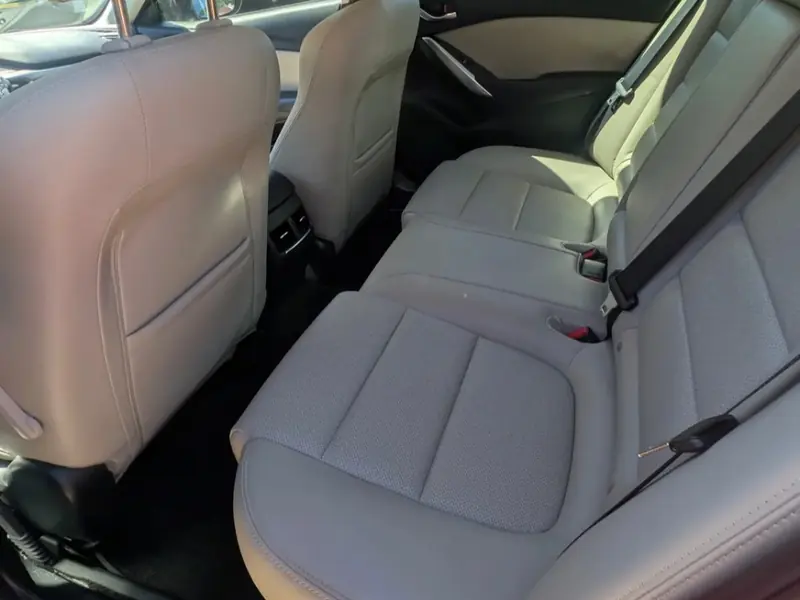 Clean light leather rear seats inside a detailed sedan