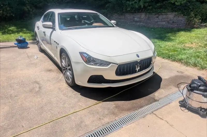 Glossy white Maserati sedan parked after detailing